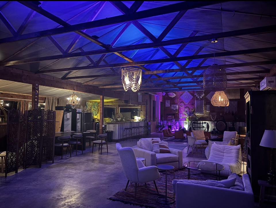 An interior lounge at AWKN Ranch with pendant lights and blue and violet uplighting