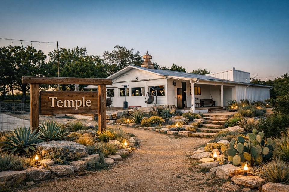 The Temple building at AWKN Ranch at dusk, with its wooden sign and a cactus garden path